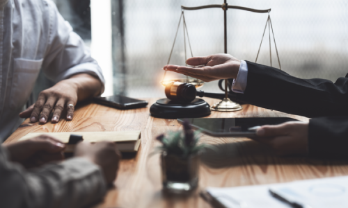 A wills lawyer in talks with a client in an office discussing an estate plan.